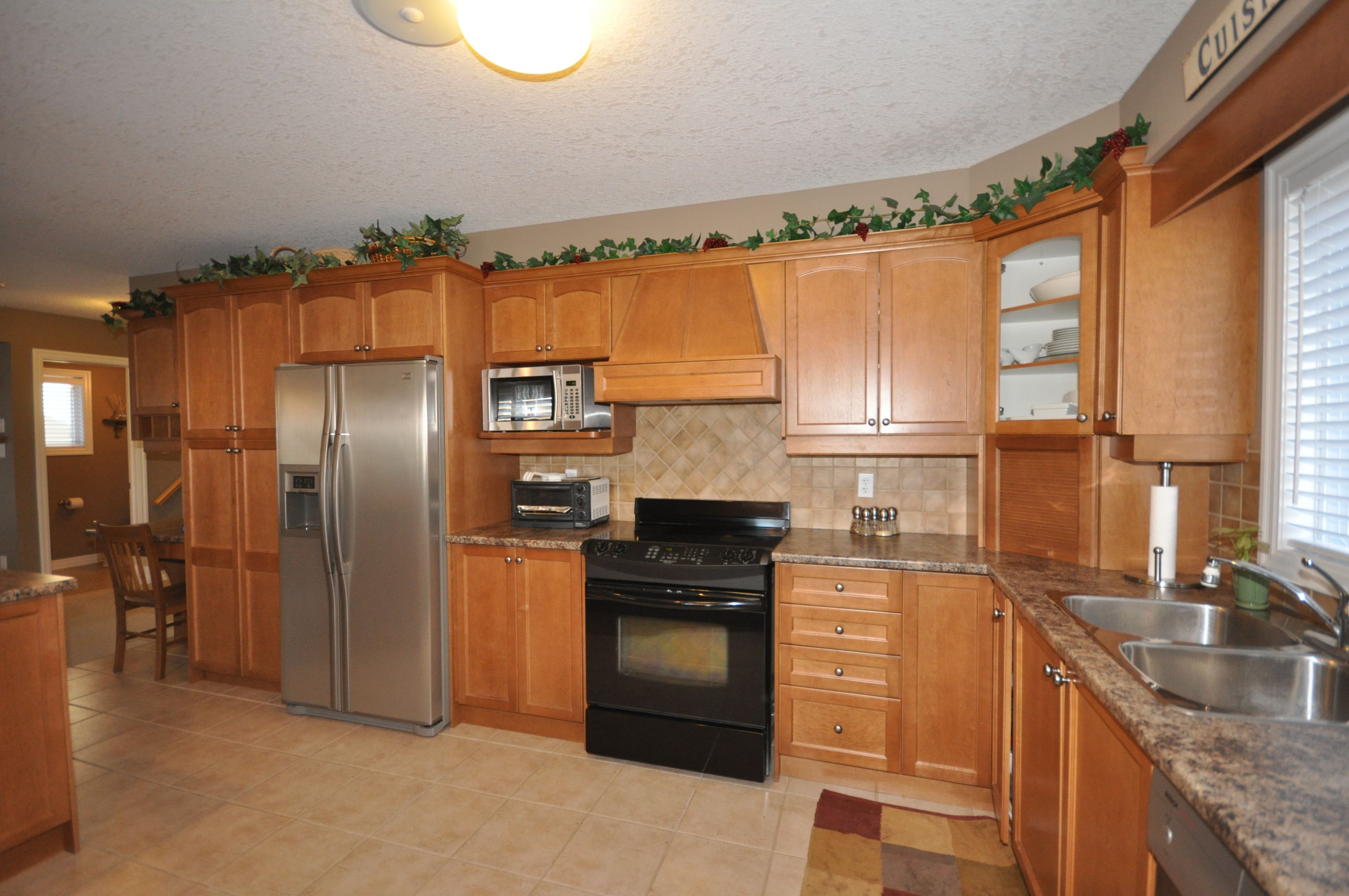 Spacious kitchen has ceramic backsplash & flooring