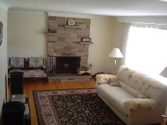 Bright Living room boasts a stone fireplace and coved ceilings 