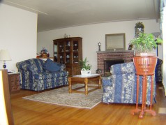 Living room with gleaming hardwood floors & woodburning fireplace 