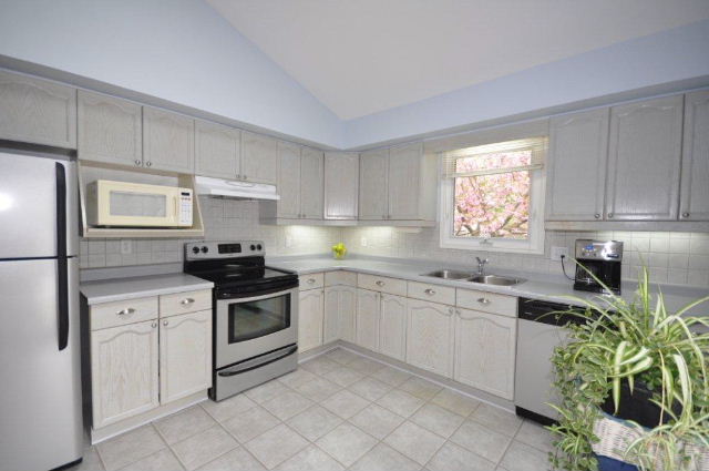 The kitchen has a soaring ceiling, lots of cupboard and counter space