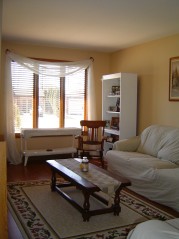 Large living room with bright sunny window & laminate flooring 