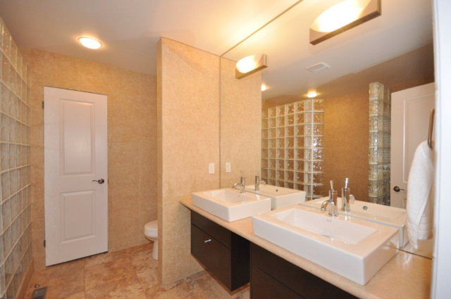 Ensuite has espresso cabinets with vessel sinks