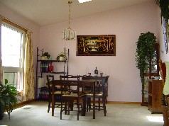 Family sized dining room that enjoys both a window and a skylite and a soaring cathedral ceiling.