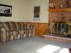 The family room has a cozy fireplace, beamed ceiling and a patio door to a 4 seasons room 