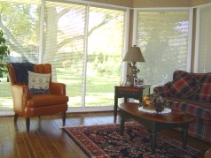 Family area off dining room surrounded by floor to ceiling windows and a patio door to the back yard 