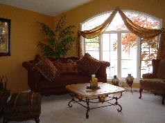 Formal living area boasts soaring ceiling and large sunny window 