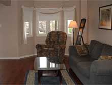 Bright and spacious living room with gleaming hardwood and bay window