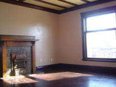 Large living room with hardwood floors and fireplace in the upper unit 