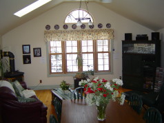 Fire lit family room with soaring ceilings and sunny windows